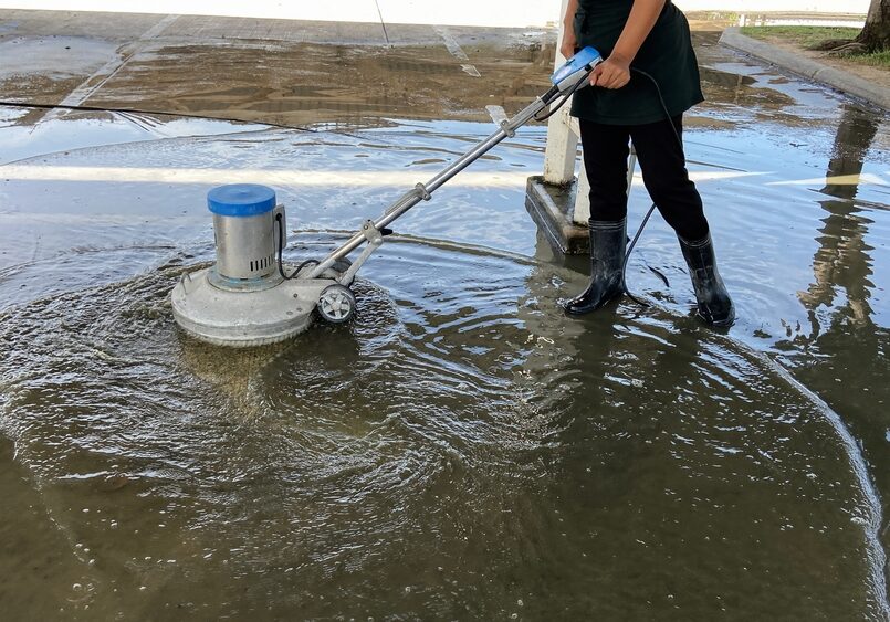 Employees,Use,A,Concrete,Floor,Scrubber,In,The,Office,Parking